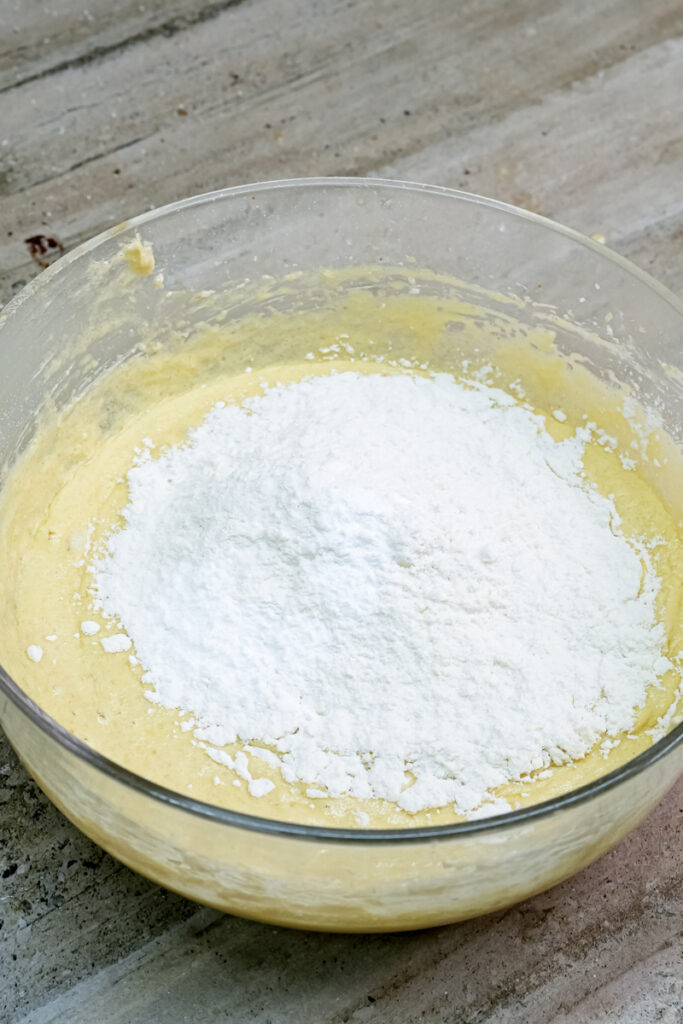 Adding flour to wet ranger cookie ingredients in mixing bowl