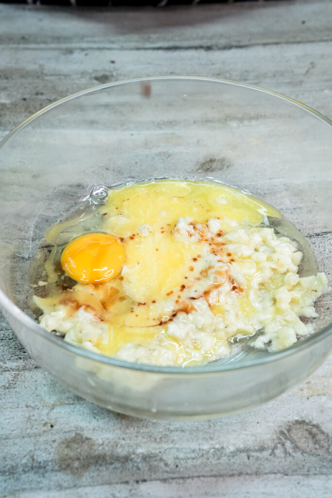 Adding vanilla extract to a bowl of mashed bananas, eggs, and melted butter for a muffin batter.Adding vanilla extract to a bowl of mashed bananas, eggs, and melted butter for a muffin batter