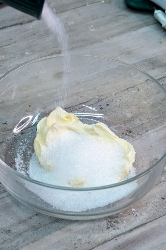 Adding white sugar to butter