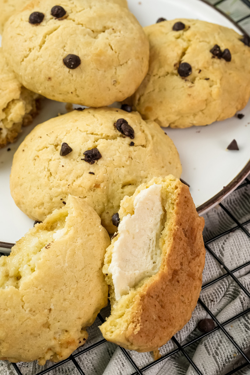 Broken cheesecake cookie showing creamy cheese filling inside
