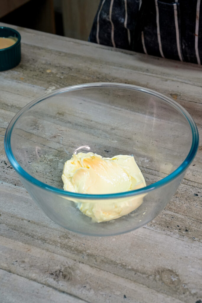 Butter softening in a clear glass mixing bowl