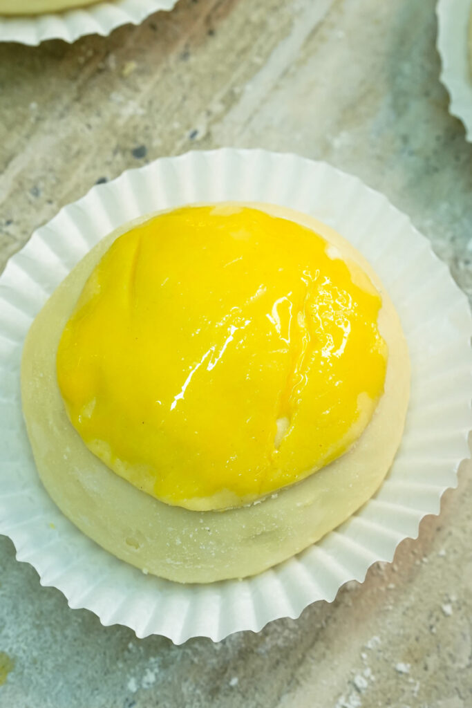 Completed pineapple bun with golden cookie topping ready to bake