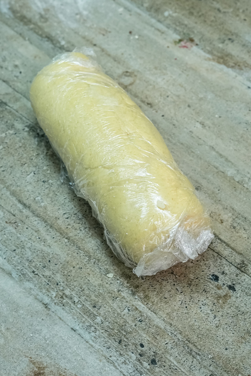 Cookie dough rolled into log shape wrapped in plastic wrap