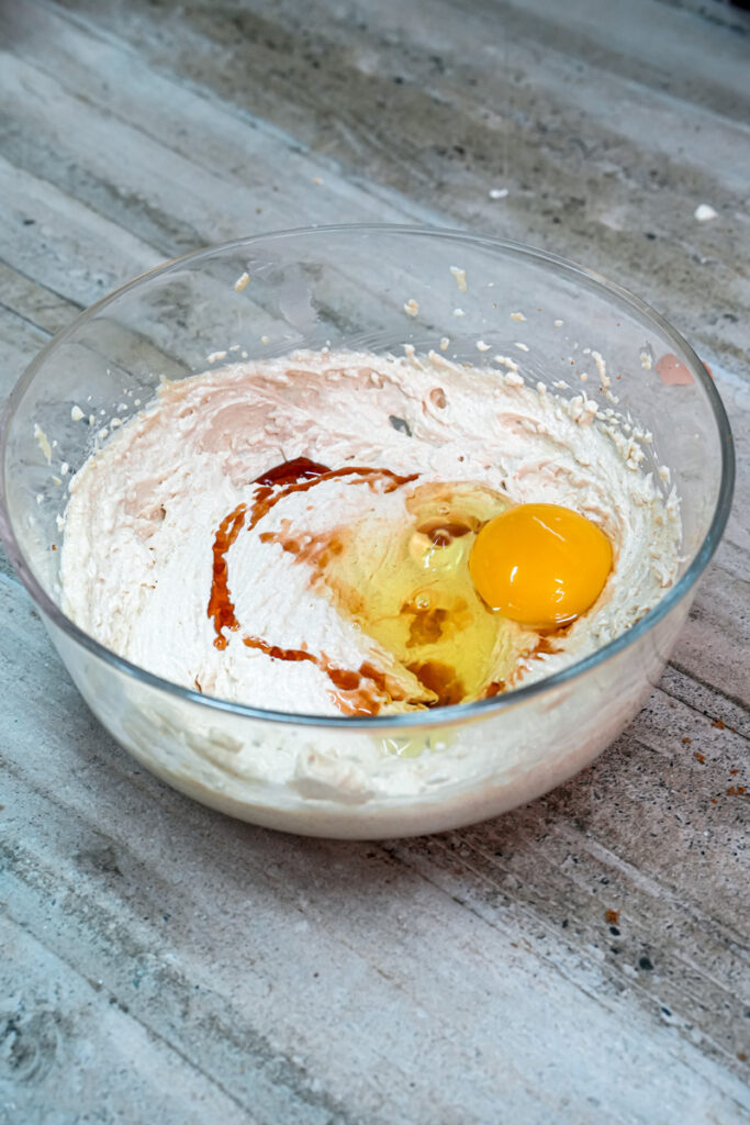 Cracking egg into cookie dough mixture