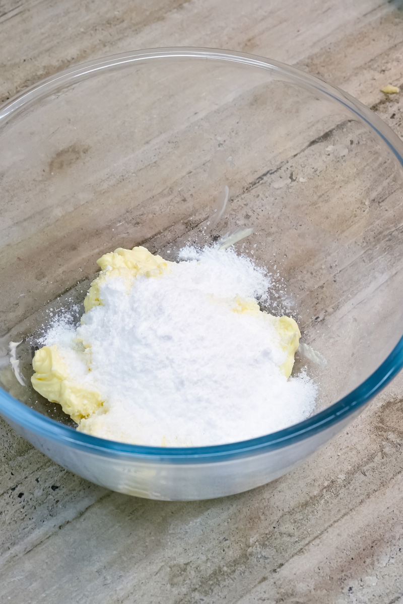 Creaming butter and powdered sugar in glass mixing bowl for Mexican wedding cookies