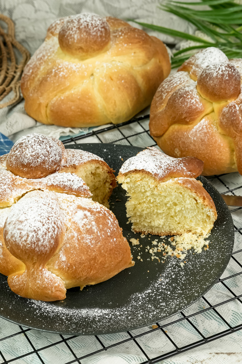 Fresh baked Pan de Muerto with traditional bone decorations and powdered sugar dusting