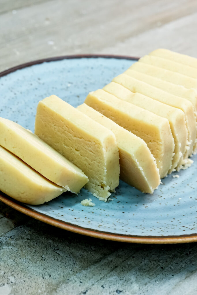 Fresh cut shortbread cookie dough pieces showing texture on serving plate