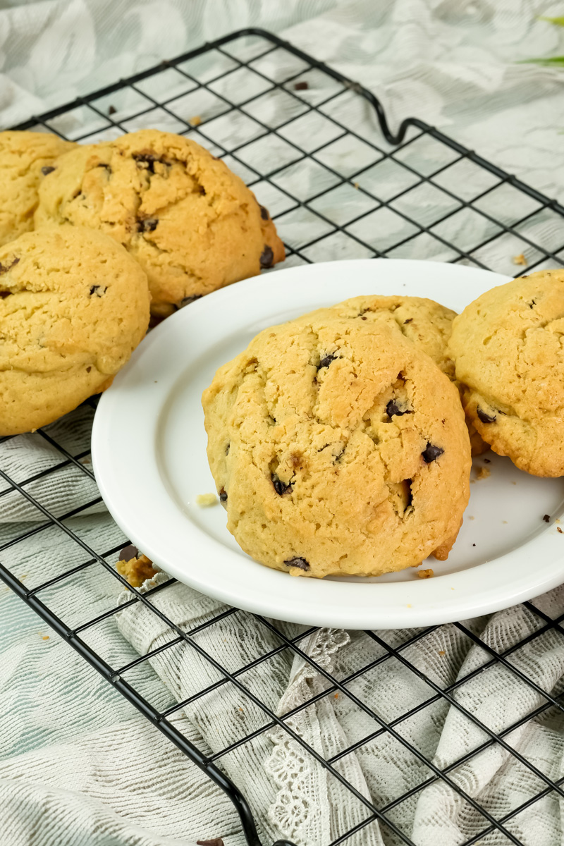 Freshly baked cookies on a white plate and cooling rack