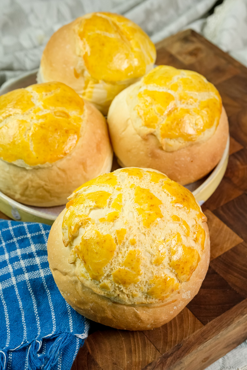 Freshly baked golden pineapple buns on wooden cutting board