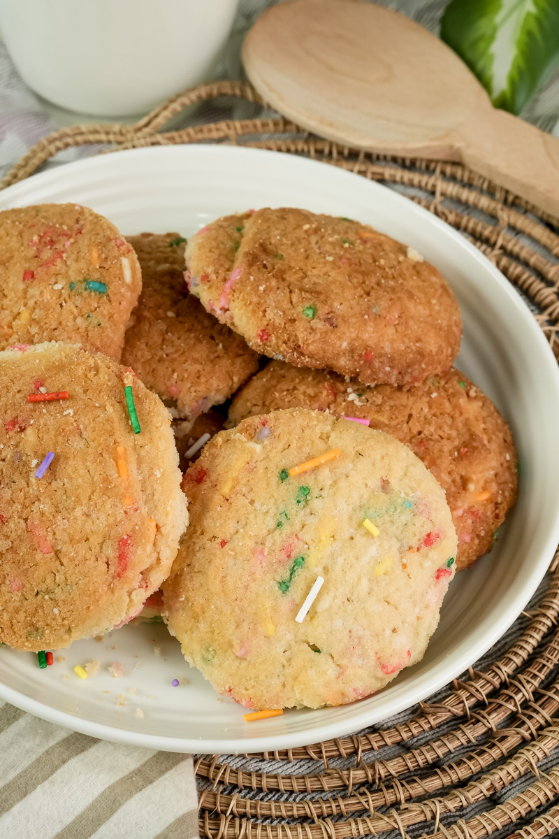 Funfetti cookies on a plate with scattered sprinkles