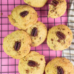 Golden brown Pecan Pie cookies on a pink background