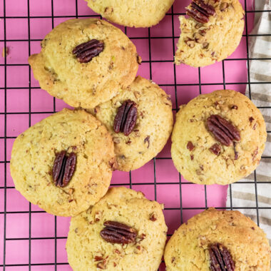 Golden brown Pecan Pie cookies on a pink background