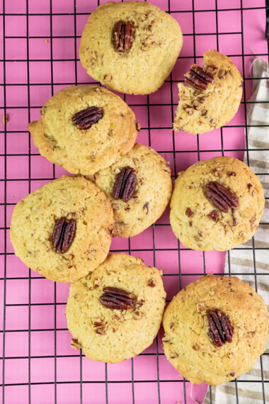 Golden brown Pecan Pie cookies on a pink background