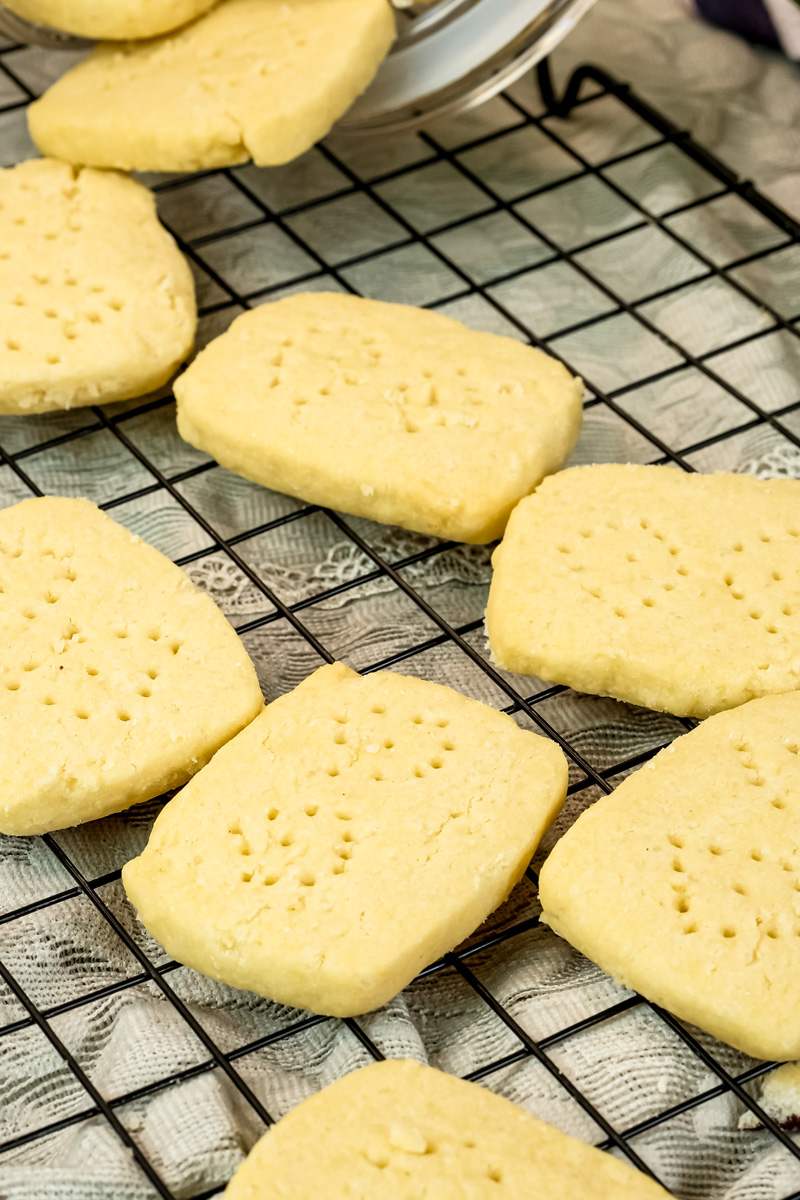Golden brown shortbread cookies with fork marks on cooling rack