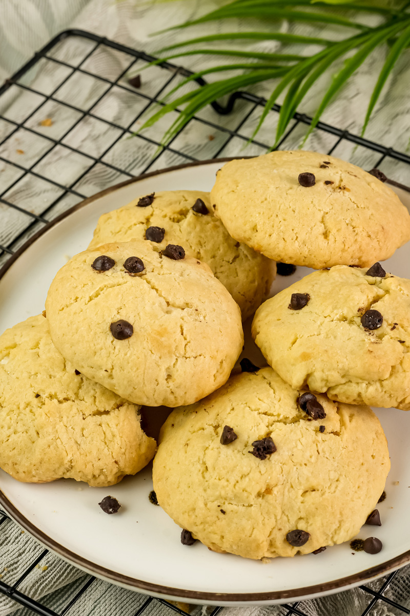 Golden cheesecake cookies with chocolate chips cooling on wire rack