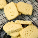 Golden shortbread cookies with fork holes cooling on wire cooling rack