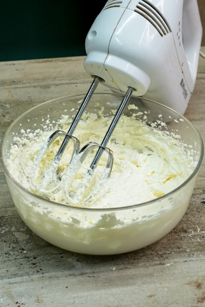 Hand mixer whipping cookie dough with beaters visible
