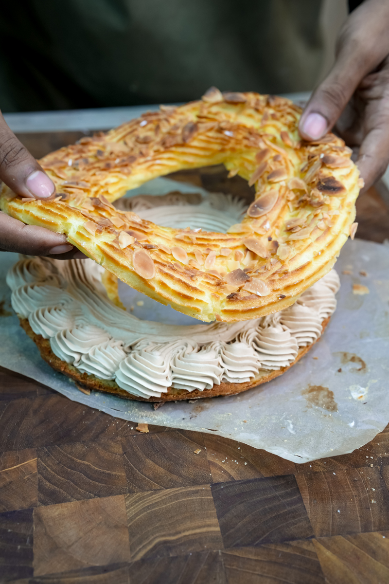 Lifting Paris Brest section to show cream filling