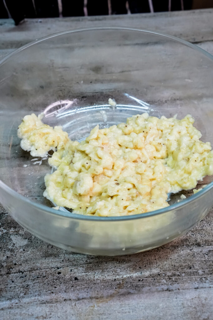 Mashed bananas in a clear mixing bowl