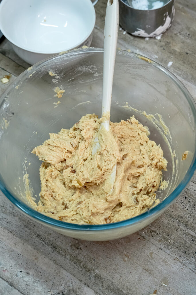 Mixed oatmeal raisin cookie dough in glass mixing bowl