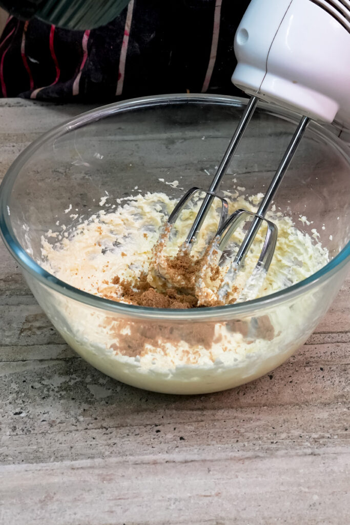 Mixing brown sugar into creamed butter and sugar