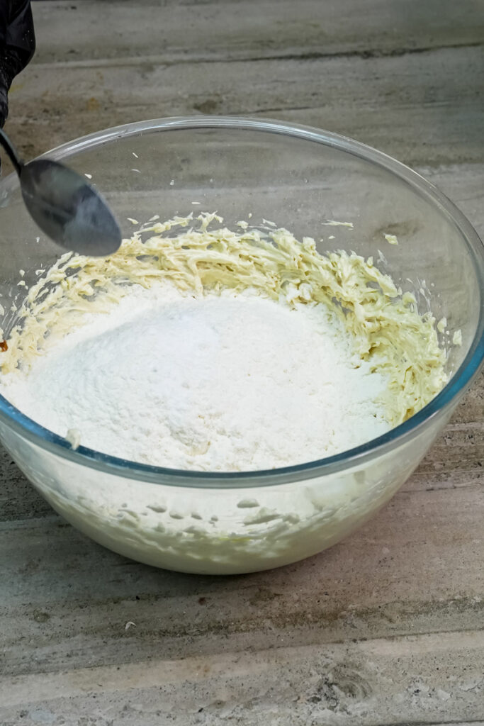 Mixing dry ingredients into the cookie dough mixture with a spoon