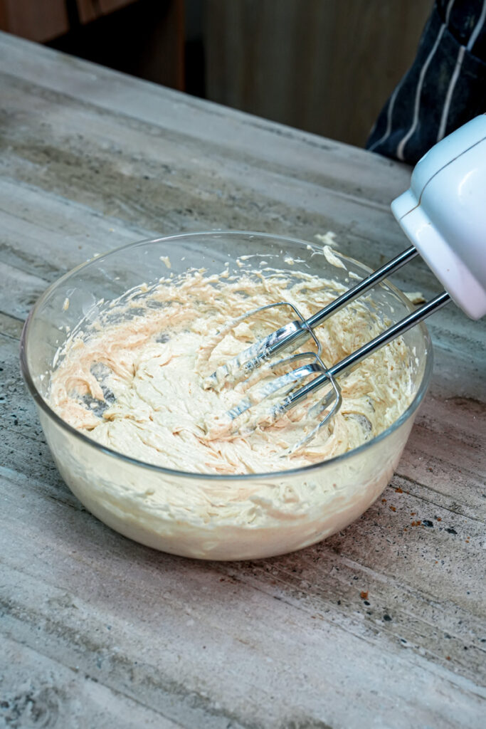 Mixing egg into cowboy cookie dough with electric mixer
