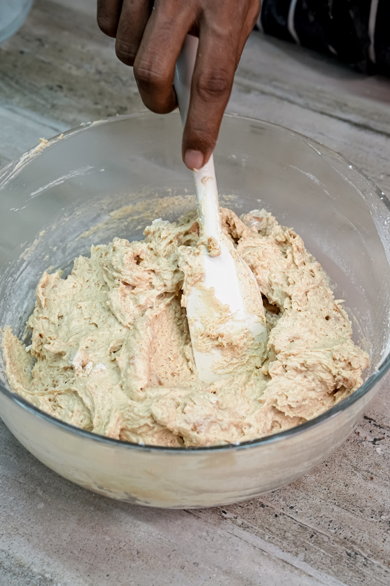 Mixing s'mores cookie dough in glass bowl with wooden spoon
