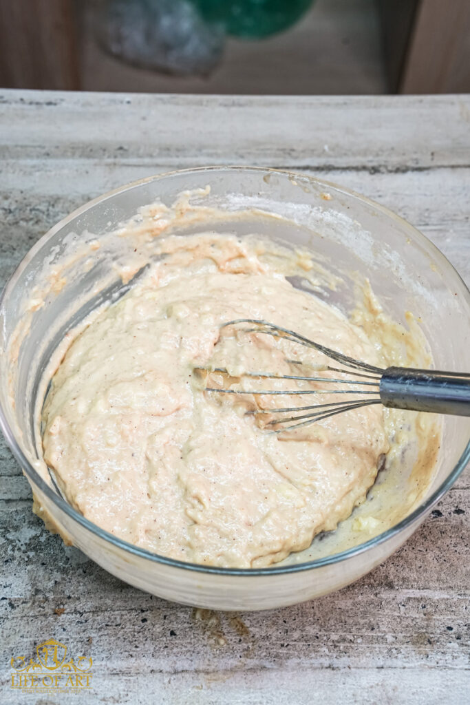 Mixing the banana muffin batter with a wire whisk