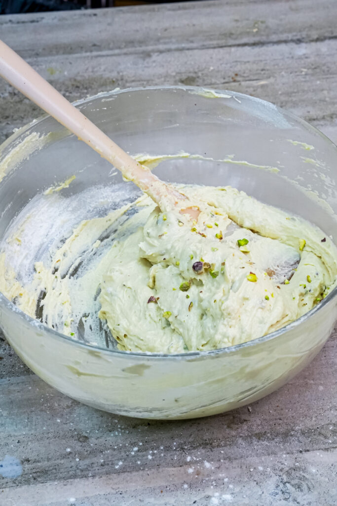 Mixing the pistachio pieces into the cookie dough