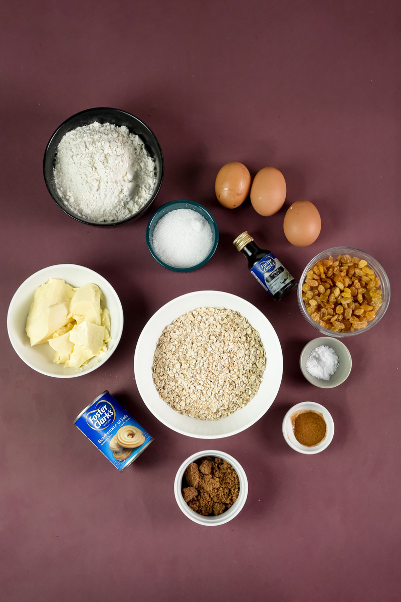 Oatmeal raisin cookie ingredients laid out on purple surface