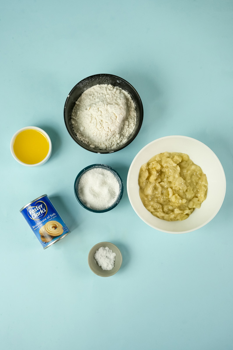 Overhead shot of banana cookie ingredients, including mashed bananas, flour, sugar, butter, and baking soda