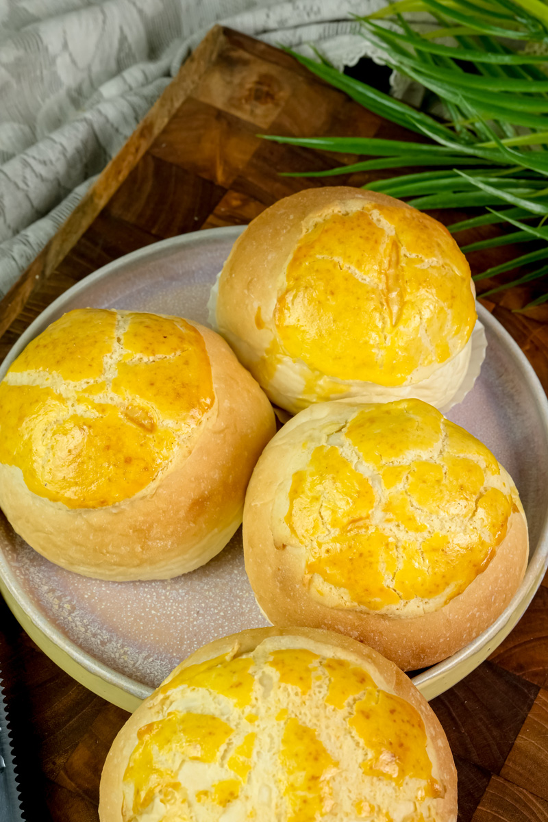 Pineapple buns with golden crackled tops on serving plate