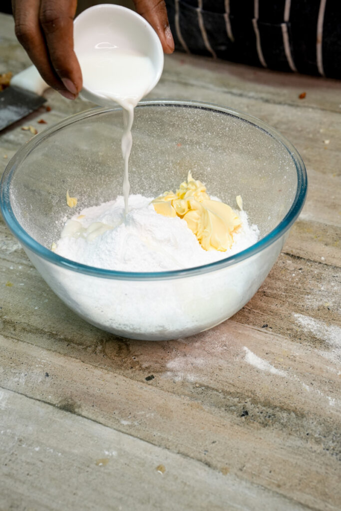 Pouring milk into flour mixture for pineapple bun recipe
