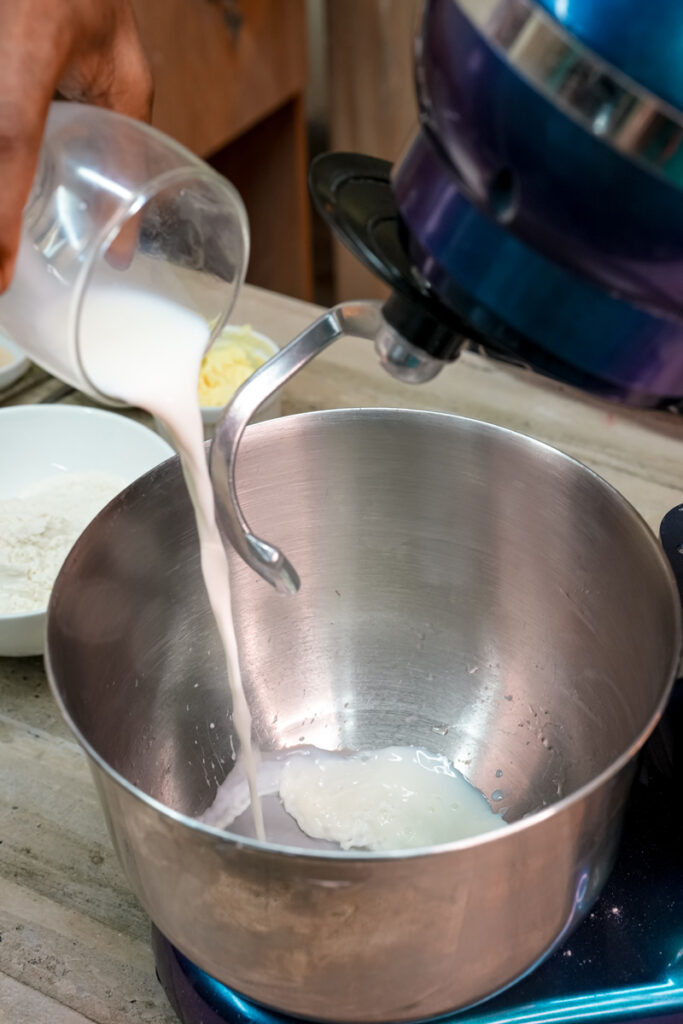 Pouring milk into saucepan for pineapple bun dough