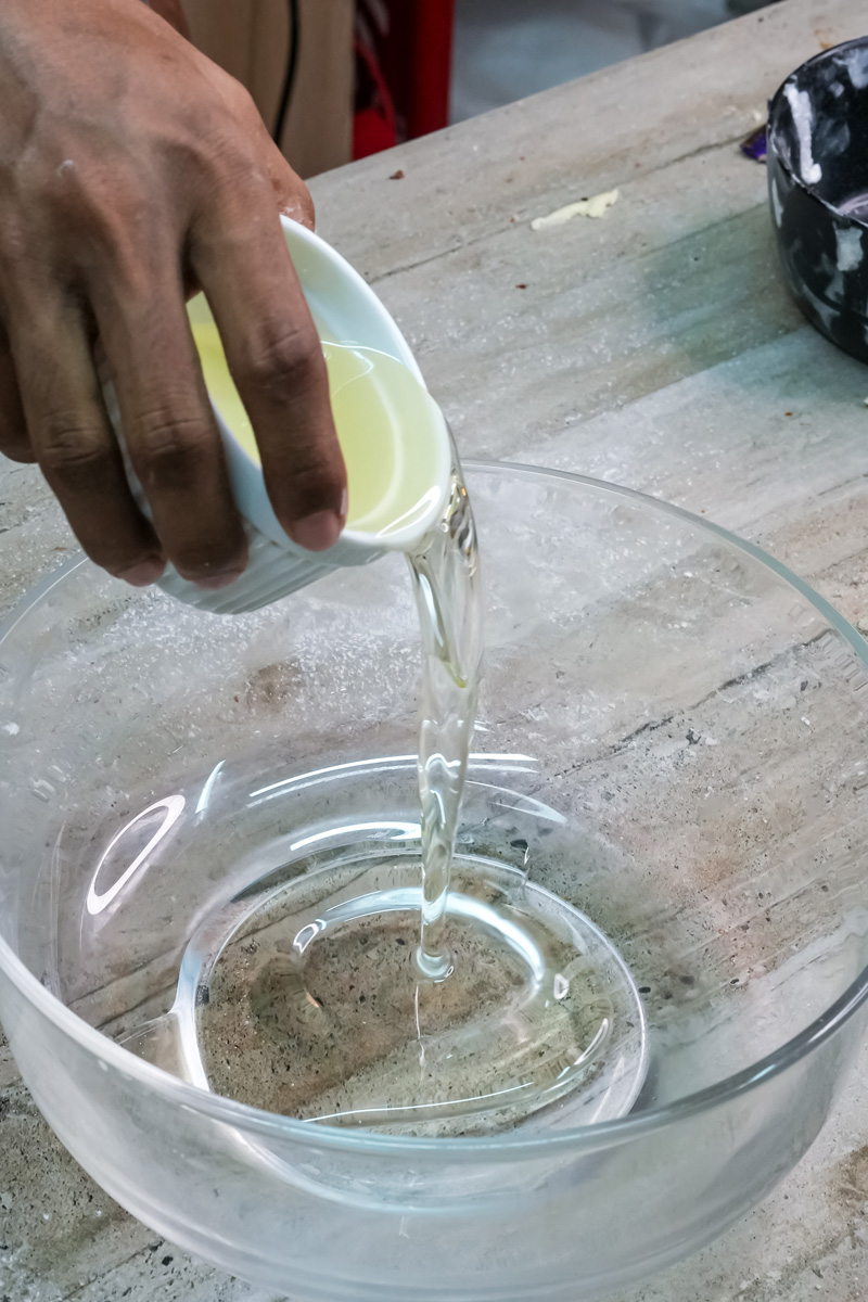 Pouring oil into glass mixing bowl for molasses cookies