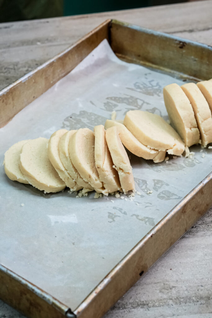 Raw Twix cookie rounds arranged on parchment-lined baking sheet