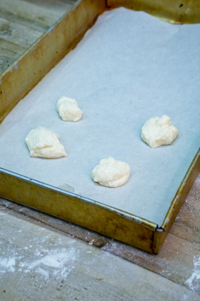 Raw cheesecake cookie dough portions on baking sheet
