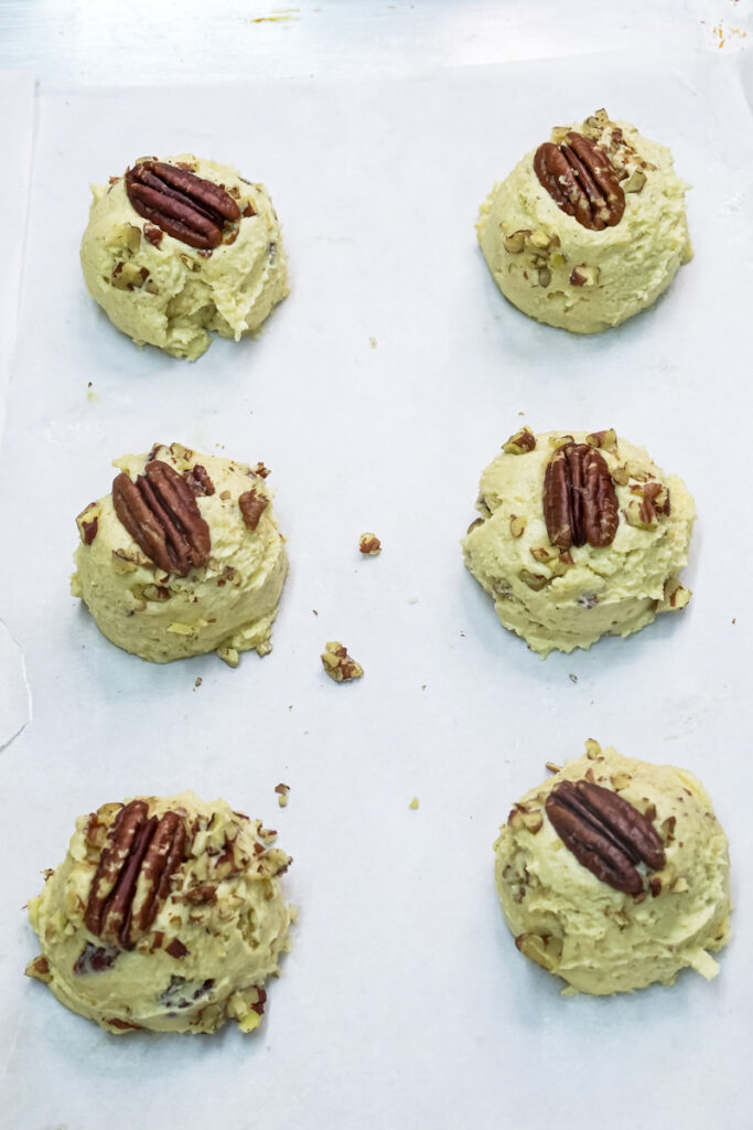 Raw cookie dough balls topped with a whole pecan
