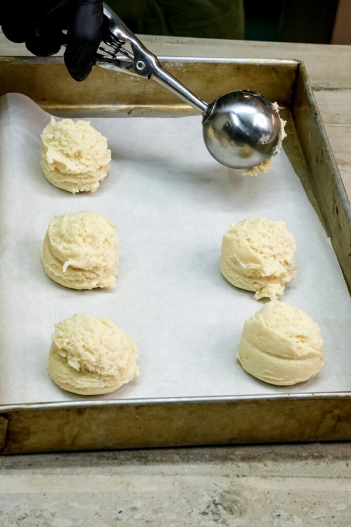 Scooping milk cookie dough onto baking sheet