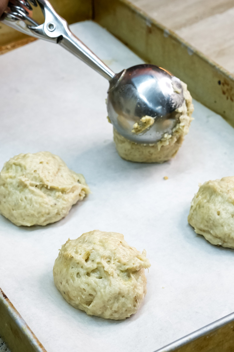 Scoops of banana cookie dough placed on a baking sheet, ready for baking
