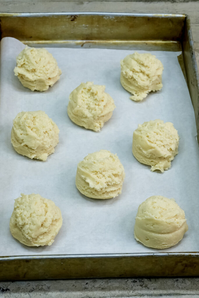 Shaped milk cookie dough balls on parchment paper