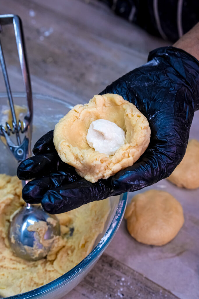 Shaping cookie dough around cream cheese filling