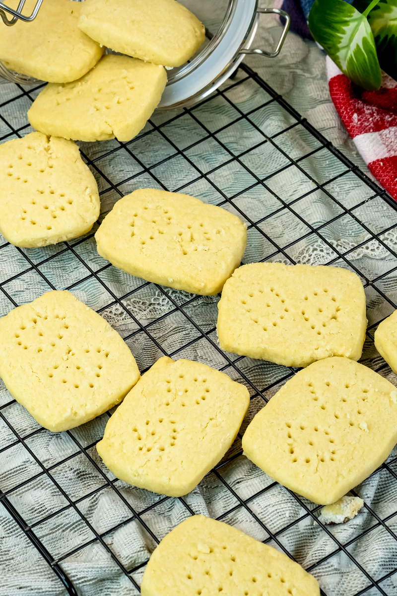 Shortbread cookies cooling on wire rack with glass storage jar