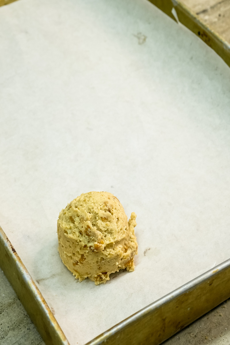 Single s'mores cookie dough ball on parchment-lined baking sheet