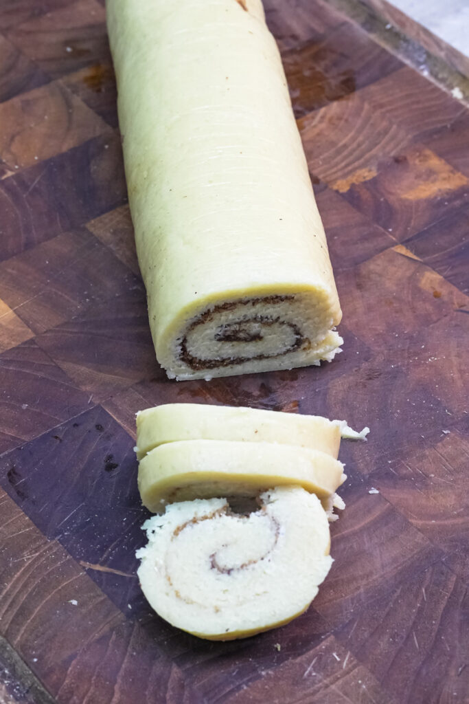 Slicing chilled cookie dough log to create the cinnamon swirl effect