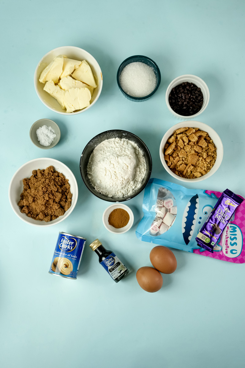 S'mores cookie ingredients laid out on blue surface