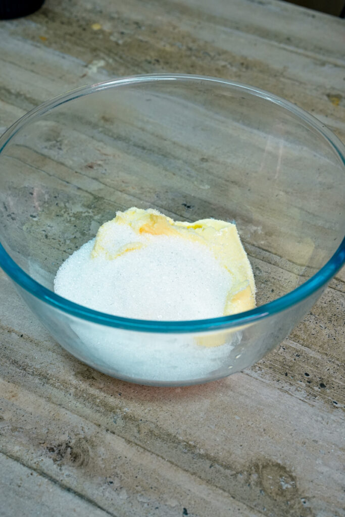 Softened butter and white sugar in a glass mixing bowl