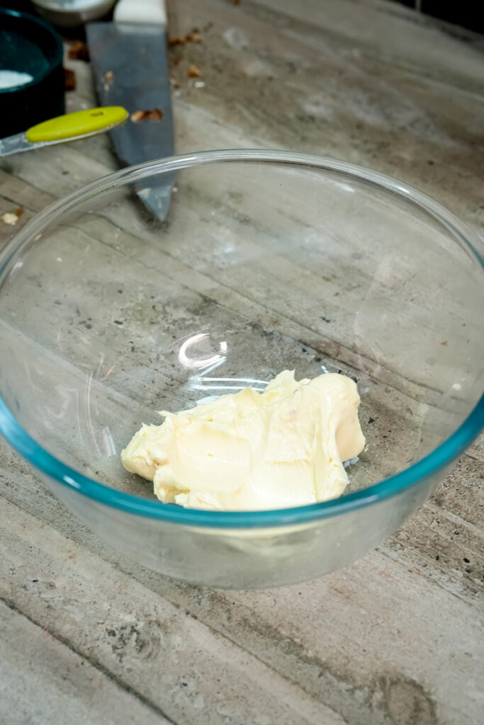 Softened butter in glass mixing bowl for cookie recipe