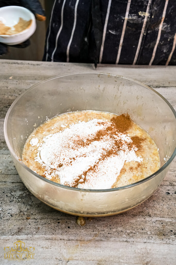 Sprinkling cinnamon and baking powder over the flour and wet ingredients